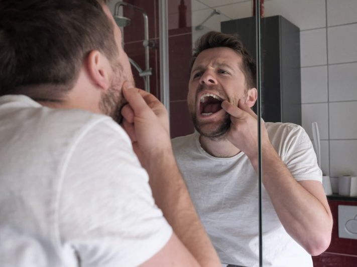 Patient checking dental crown in the mirror