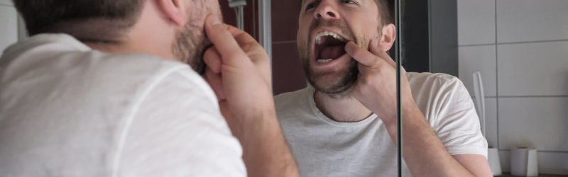 Patient checking dental crown in the mirror