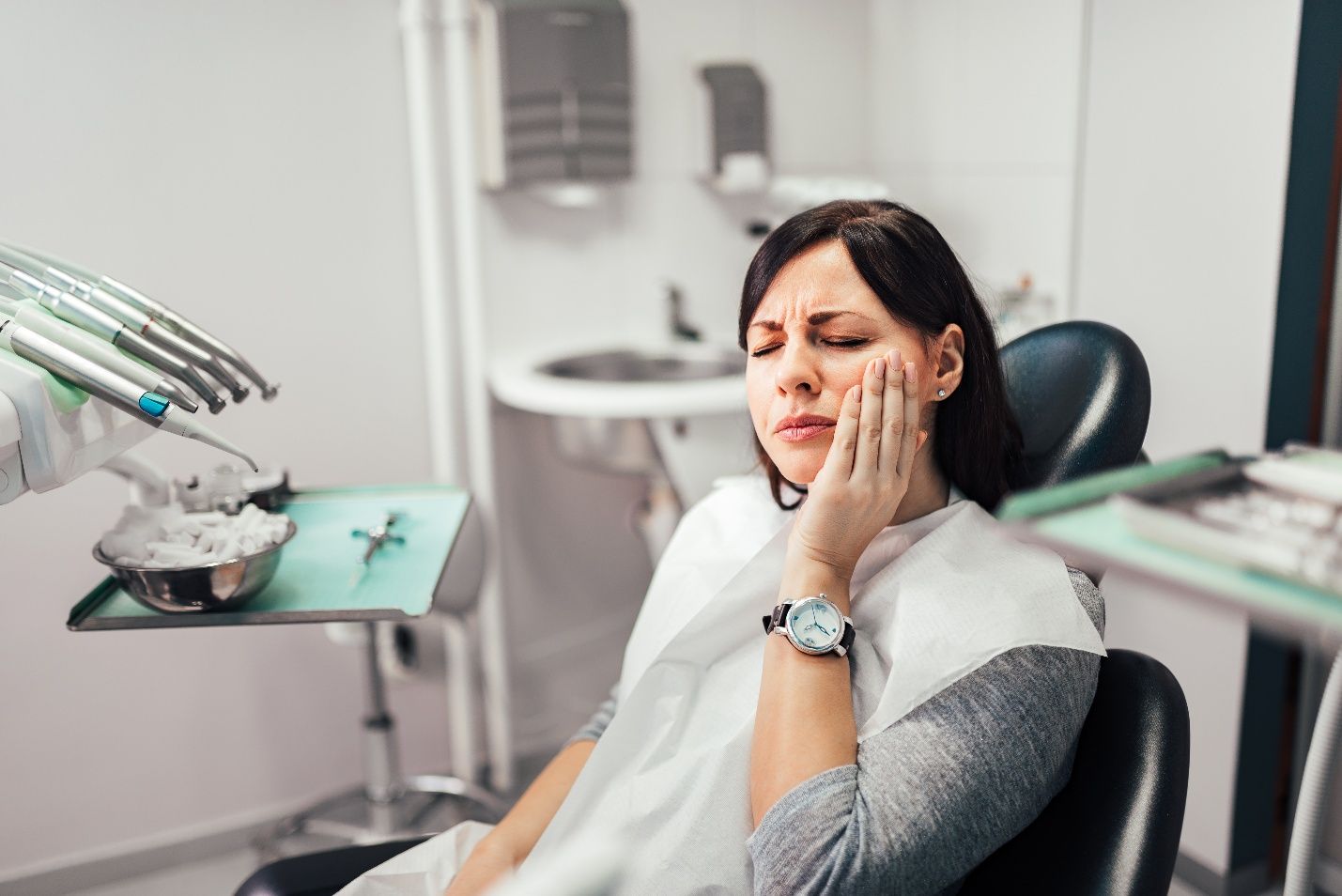 Woman with toothache sitting in treatment chair