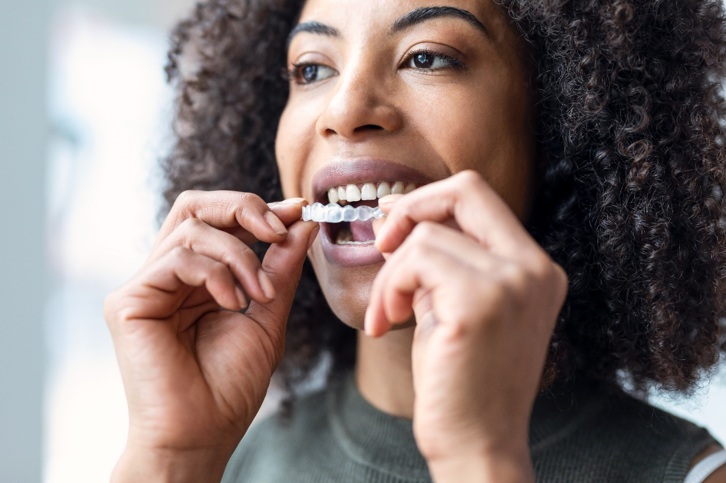  A woman putting on a ClearCorrect aligner