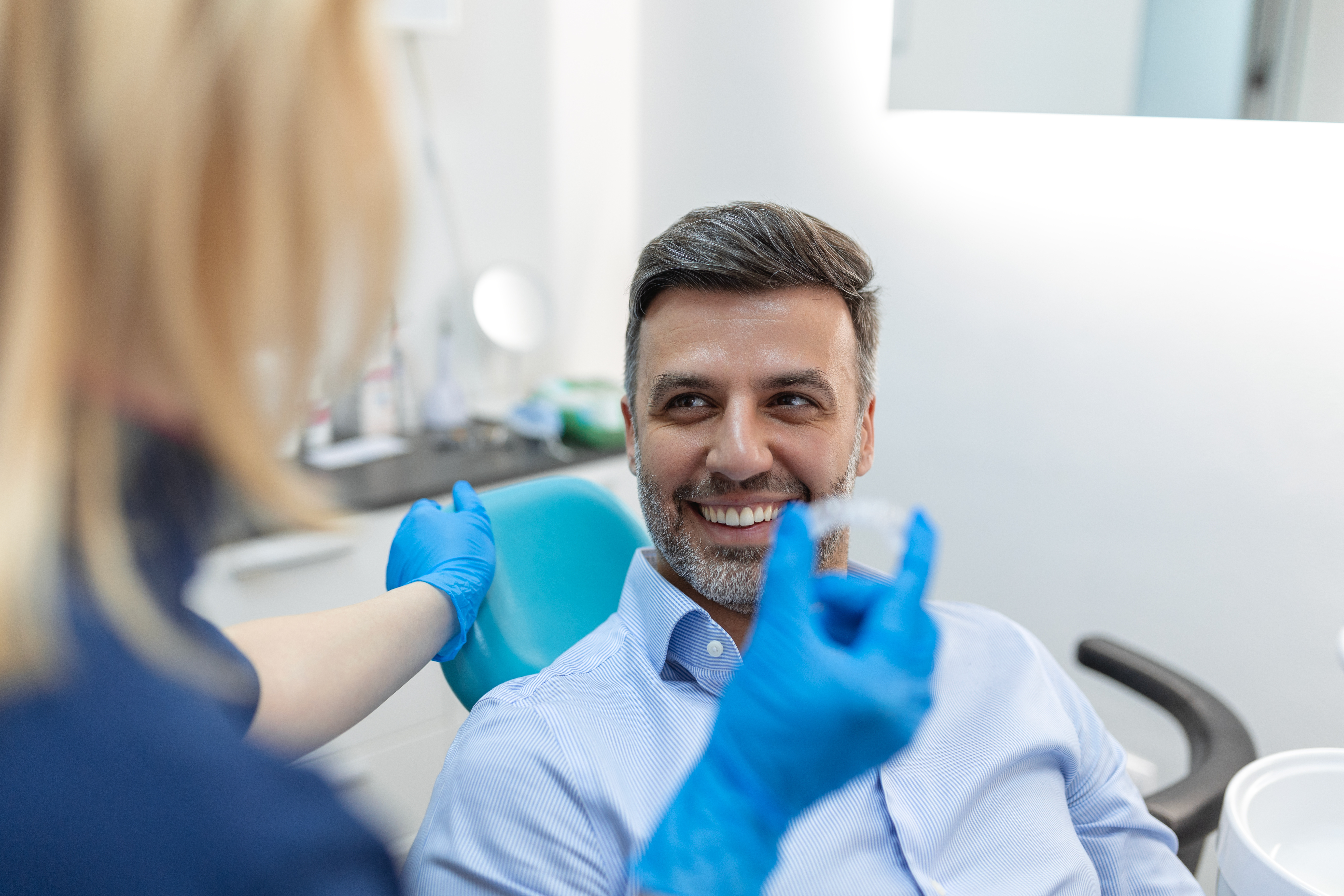 Dentist in Alpharetta showing Invisalign aligner to patient 