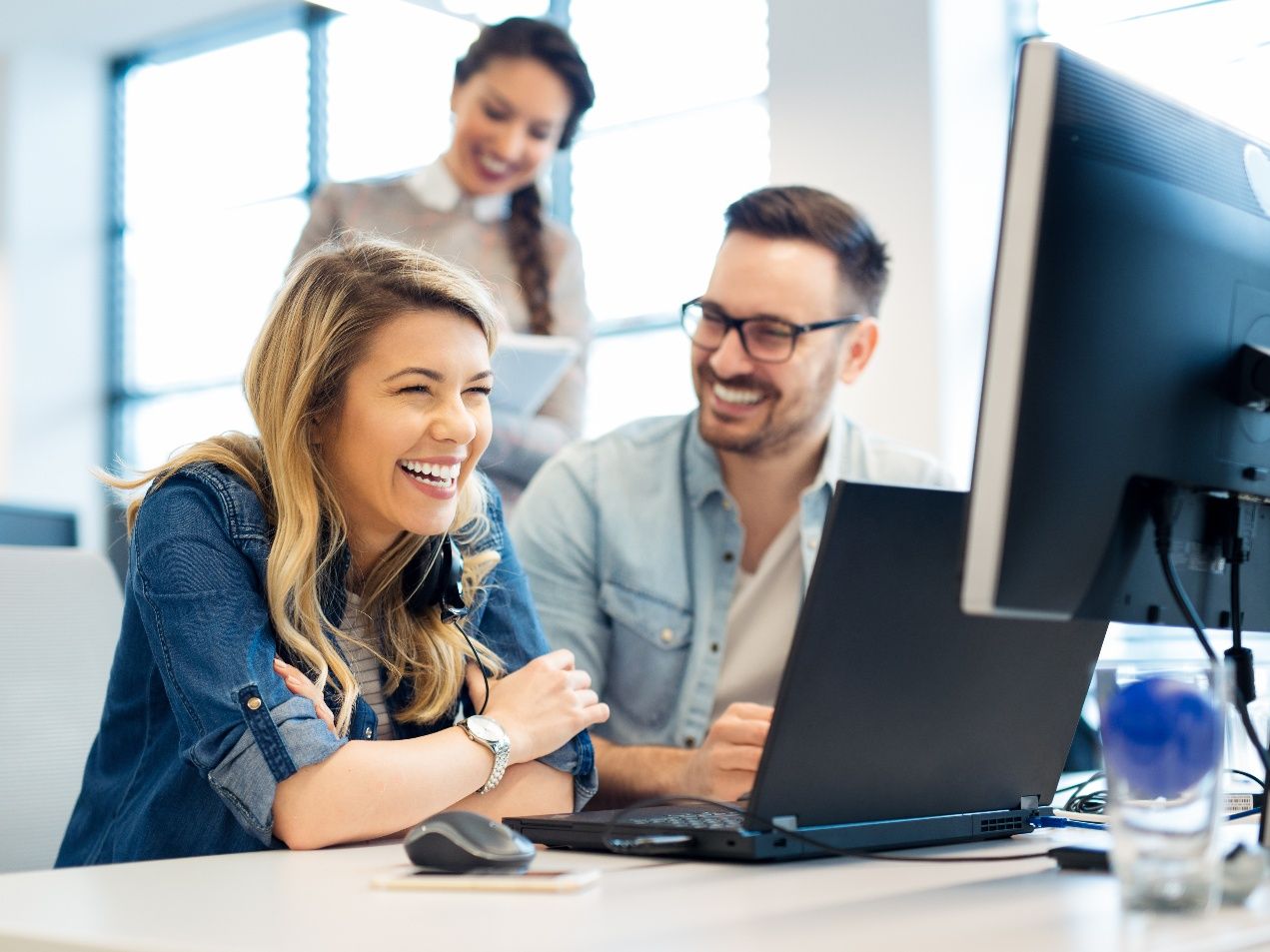 People at work smiling confidently and laughing together