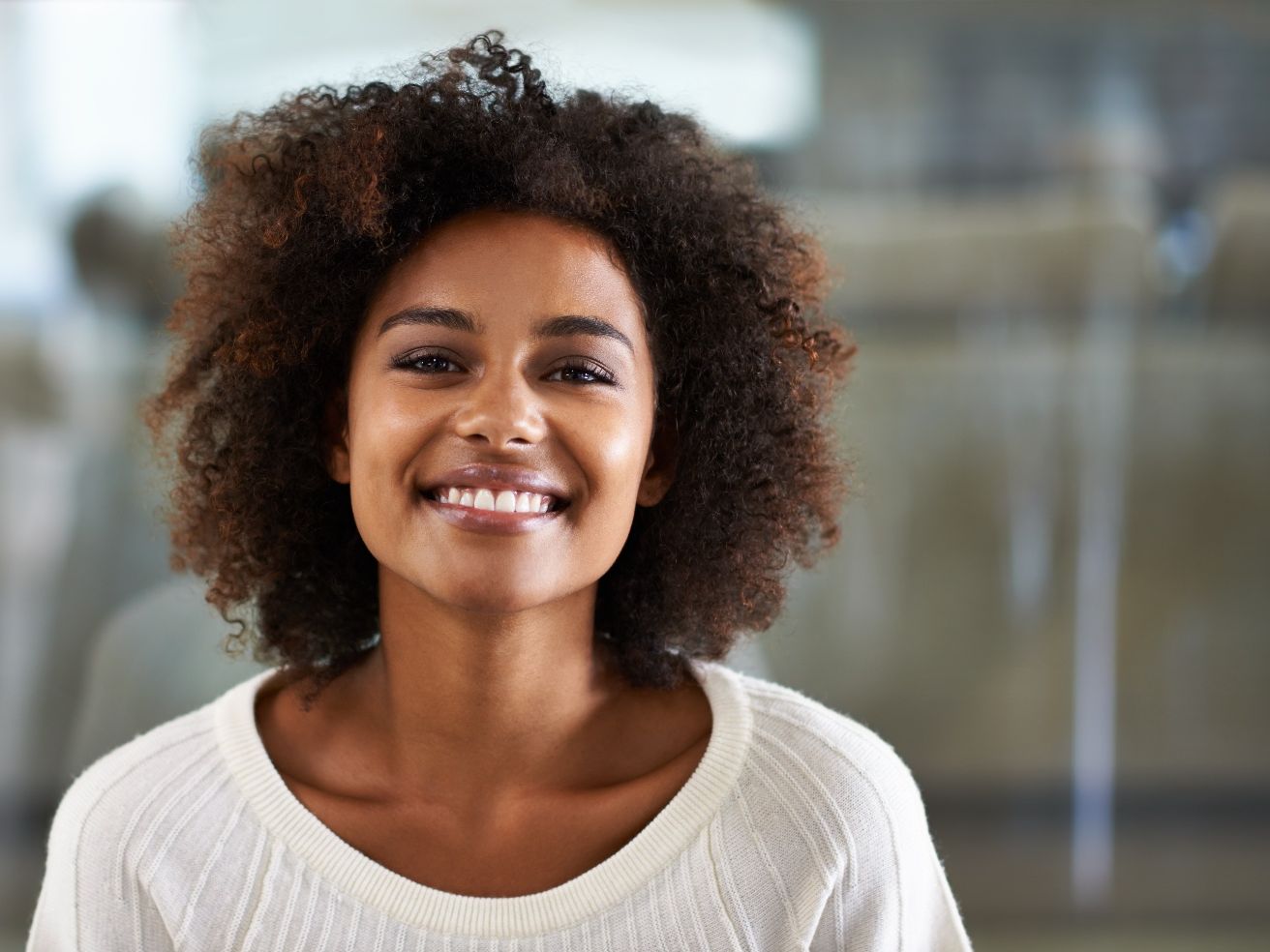 Close-up of smiling woman in white sweater